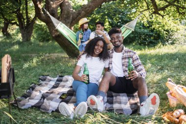 Dört farklı arkadaş doğada piknik yapıyor.