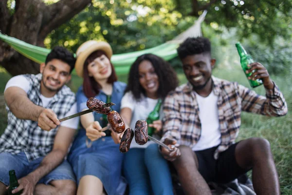 Des personnes multiculturelles pique-niquent avec des saucisses grillées — Photo