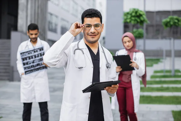 Multirazziale arabo indù squadra medica che lavora al di fuori della moderna clinica — Foto Stock