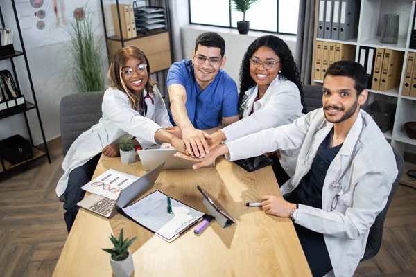 Multikulturella läkare stapla händerna tillsammans efter mötet — Stockfoto