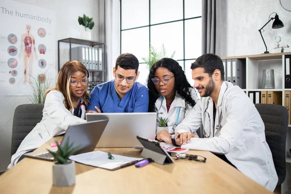 Medici multietnici qualificati che cooperano durante la riunione — Foto Stock