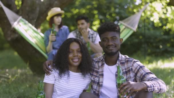 Vier verschillende vrienden genieten van picknick tijd op de natuur — Stockvideo