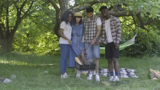 Friends gathering around barbeque for grilling sausage — Stock Video