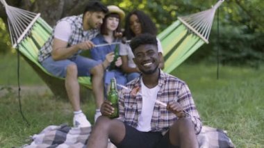 Pozitif Afrikalı bir adam arkadaşlarıyla yaz bahçesinde dinleniyor.