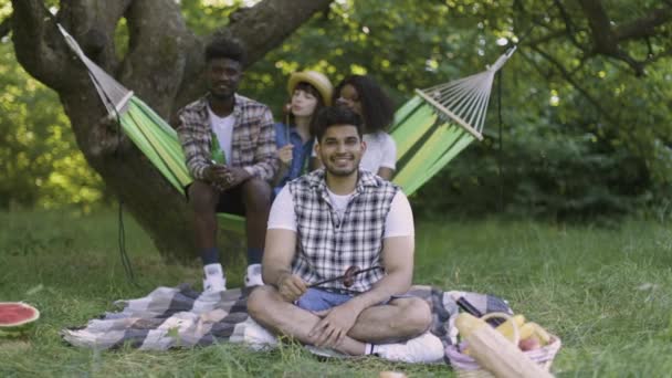 Hindoe kerel tonen duim omhoog tijdens picknick met vrienden — Stockvideo