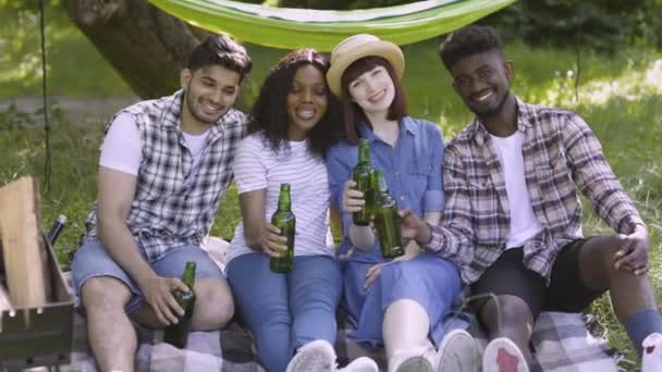 Multi etnische vrienden poseren in de tuin met bier in handen — Stockvideo