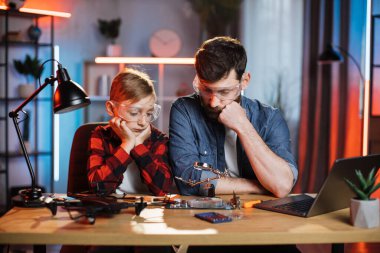 Oğlu kırık kartlara bakan düşünceli bir baba.