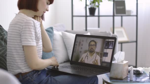 Médico varón explicando los síntomas a través de videoconferencia en portátil para paciente mujer enferma — Vídeo de stock