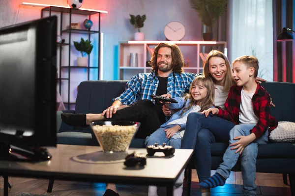 Evde televizyon izleyen mutlu bir aile.