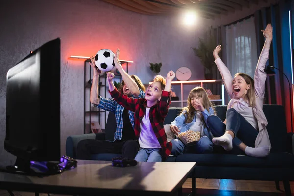 Spannende familie van vier kijkers naar voetbal op televisie — Stockfoto