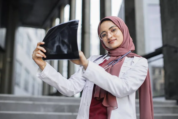Taille aus nächster Nähe Porträt einer lächelnden muslimischen Ärztin mit einem Röntgenbild. — Stockfoto