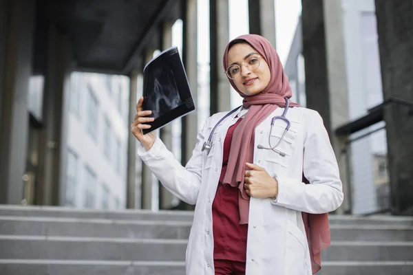 Medico musulmano donna, in piedi sulla scala della clinica moderna con immagine a raggi X in mano — Foto Stock