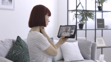 Semptomları hakkında doktoruyla konuşan hasta kadın tablet bilgisayar kullanıyor.