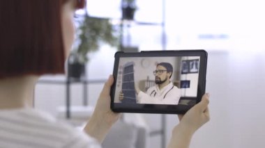 Profesyonel erkek pratisyen hasta ile bilgisayarlı tomografi sonuçları hakkında konuşuyor.
