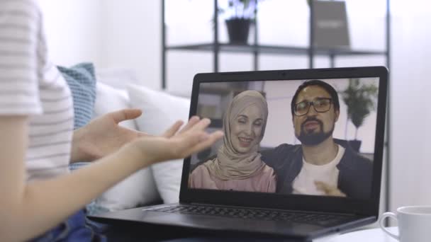 Tela de laptop com agradável jovem casal árabe ter uma chamada de vídeo com seu amigo feminino caucasiano — Vídeo de Stock