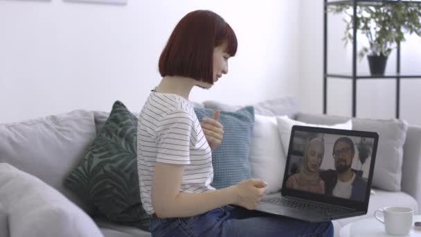 Γυναίκα χειρονομώντας ενώ μοιράζονται καλά νέα με το ζευγάρι των φίλων της, έχοντας βιντεοκλήση μέσω φορητού υπολογιστή — Αρχείο Βίντεο