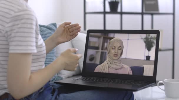 Visualizzazione dello schermo del computer portatile con giovane signora araba musulmana in hijab, tenendo una videochiamata remota ad un amico — Video Stock