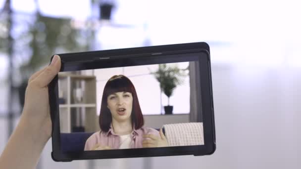 Tablet PC vista de pantalla de la mujer joven y bonita, hablando con una hembra irreconocible por videollamada — Vídeo de stock