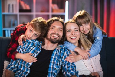 Güzel ve mutlu bir aile kanepede dinleniyor.