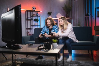 Video oyunları oynamak için joystick kullanan beyaz bir çift.