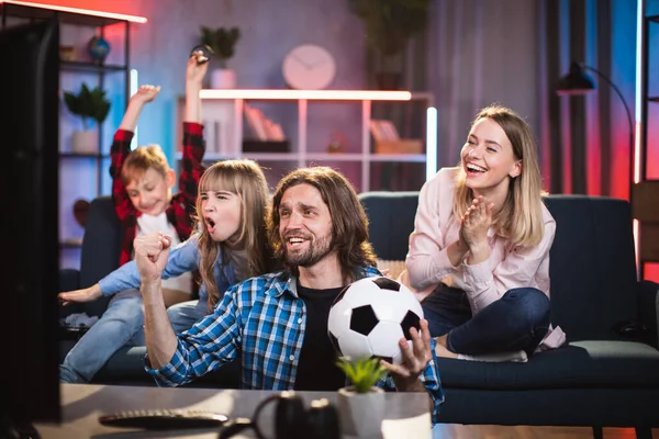 Ouders met kinderen genieten van voetbalwedstrijd op tv thuis — Stockfoto