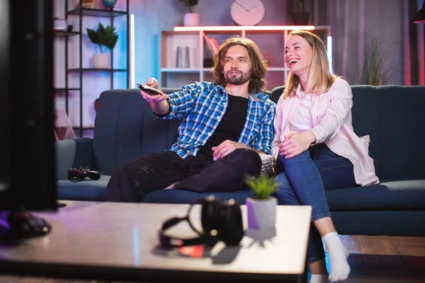Kafkasyalı çift evdeki kanepede oturup televizyon seyrediyor ve eğleniyorlar.