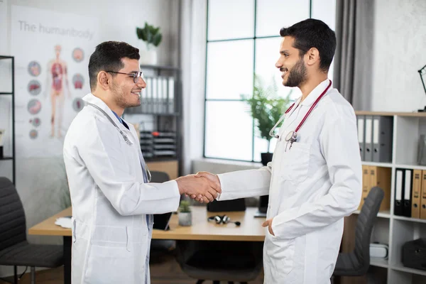 Due bravi medici arabi sorridenti alla clinica che si stringono la mano — Foto Stock