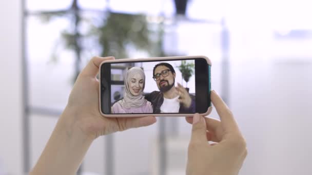 Famille musulmane, homme barbu et dame en hijab, ayant un appel vidéo en ligne avec son ami — Video