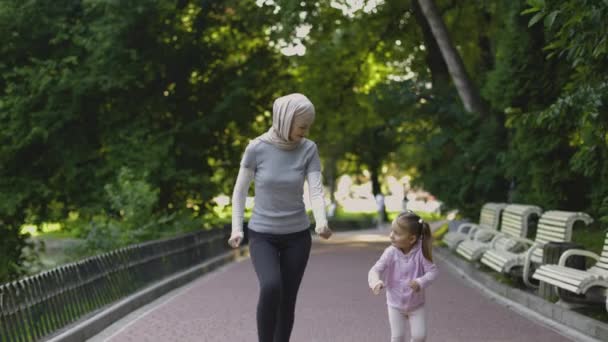 Muselman Arabian kvinna njuta av kör tillsammans i park med hennes söt aktiv 4-aged dotter — Stockvideo