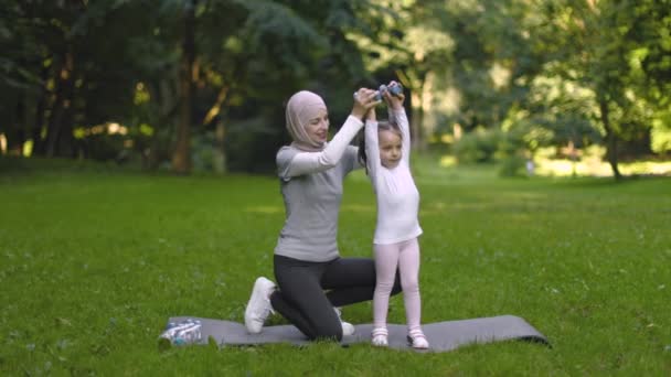 Muslimská matka učí její roztomilé dcerušky, jak dělat cvičení s činky a baví — Stock video