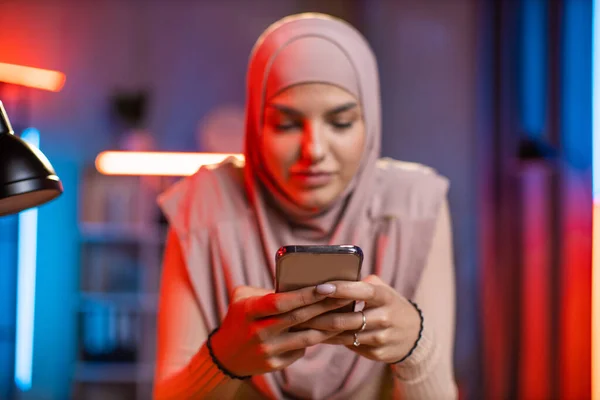 히잡에 있는 여자 가집에서 스마트폰을 사용하는 모습 — 스톡 사진