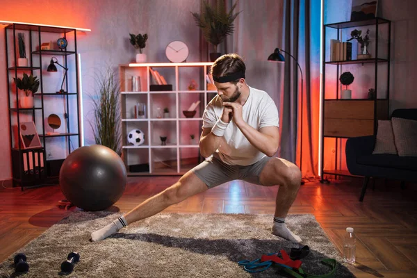 Homem de sportswear fazendo lado lunges exercícios esportivos em casa — Fotografia de Stock