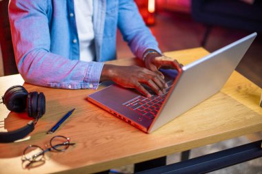 Evdeki laptopta yazan siyahi adama yaklaş.