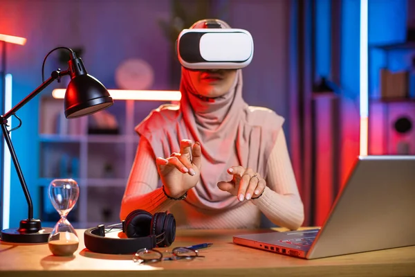 책상에 앉아서 노트북을 사용하며 VR 안경을 쓴 여성 — 스톡 사진