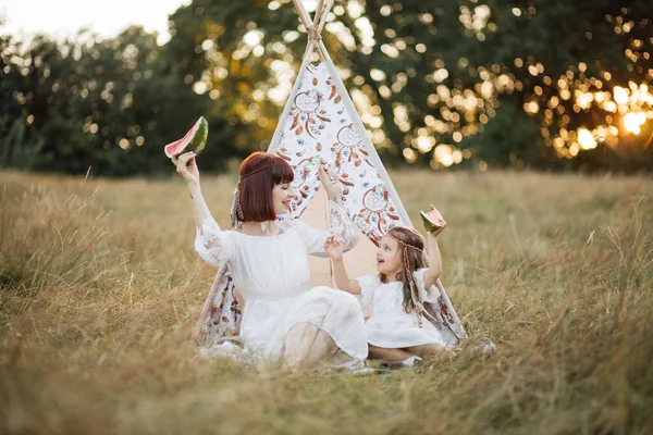 Mãe e filha da família Anericana nativa feliz, relaxando no piquenique da natureza, comendo melancia — Fotografia de Stock