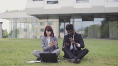 Ofis dışında modern aletler kullanan iki çok ırklı profesyonel iş adamı..