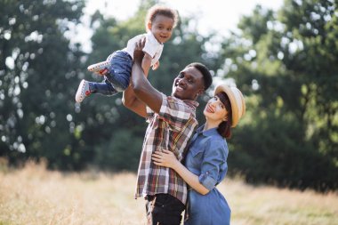Küçük oğlu doğayla oynayan çok kültürlü bir aile.