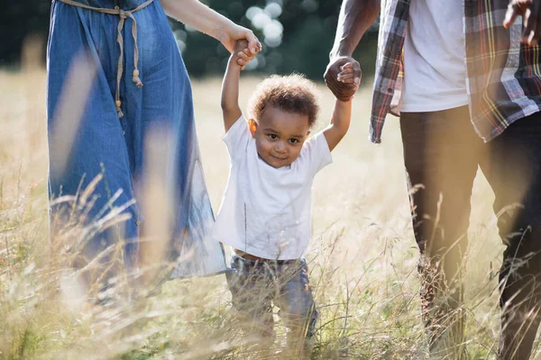 Mulher branca e homem africano andando com filho ao ar livre — Fotografia de Stock