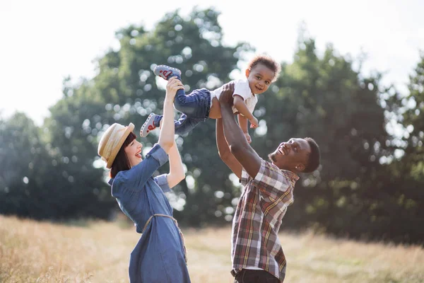 Karışık ırk ebeveynleri oğluyla dışarıda oynuyorlar. — Stok fotoğraf