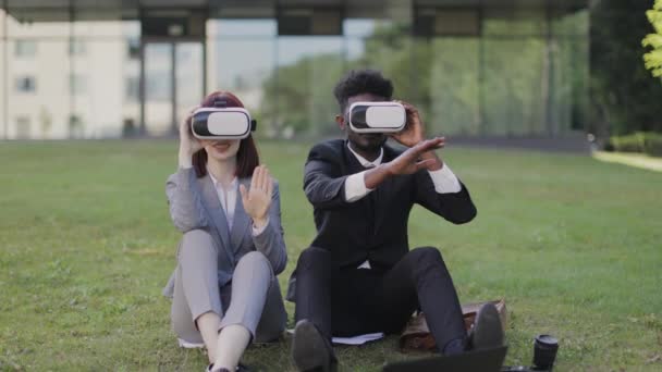 Jóvenes compañeros multirraciales que usan auriculares de realidad virtual al aire libre — Vídeo de stock