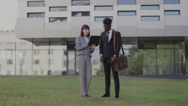 Mannelijke en vrouwelijke zakenpartners schudden elkaar de hand na ondertekening van het contract, staan buiten kantoor — Stockvideo