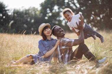 Yaz pikniğinde oynayan mutlu çok ırklı aile.