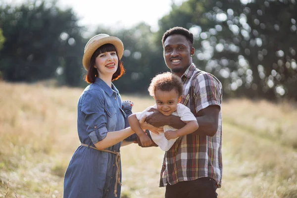 Padres multirraciales divirtiéndose con su pequeño hijo en la naturaleza — Foto de Stock