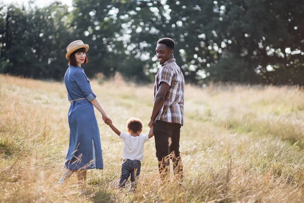 Multi família étnica de três caminhando no campo de verão — Fotografia de Stock