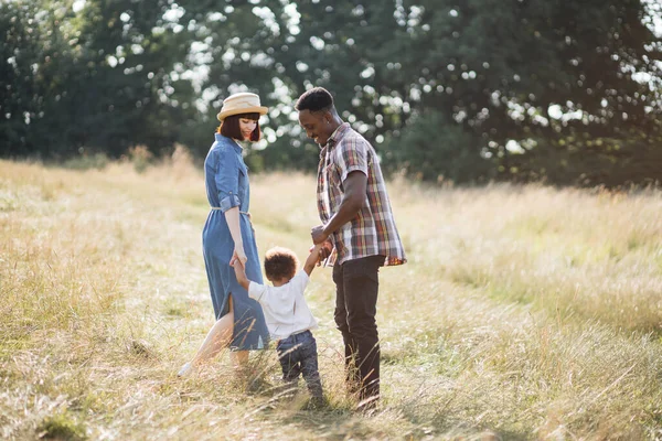 Felices padres multiculturales con hijo divirtiéndose al aire libre — Foto de Stock