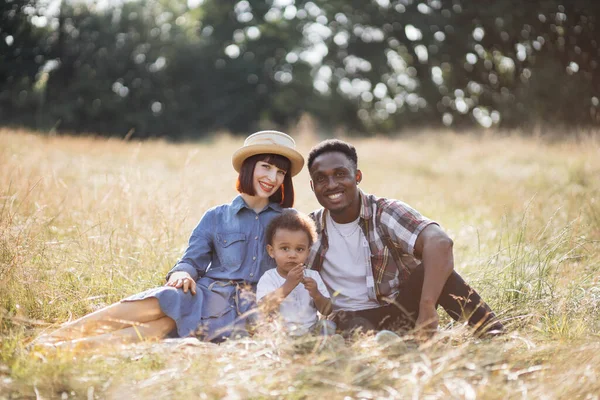 Retrato de família multirracial feliz fazendo piquenique na natureza — Fotografia de Stock