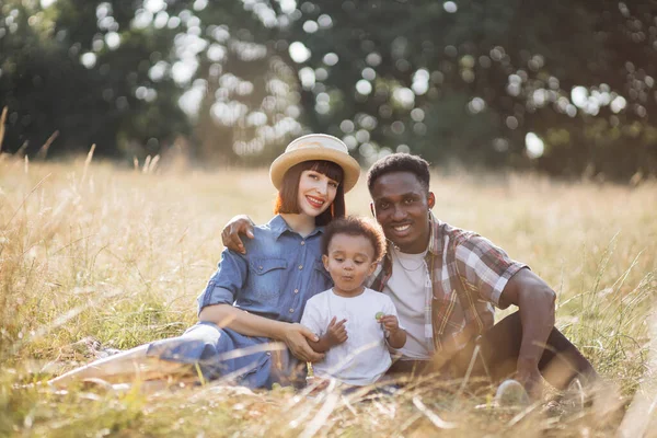 Africano pai e caucasiano mãe desfrutar de piquenique bonito filho — Fotografia de Stock