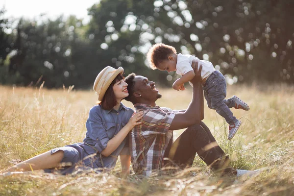 Família multi étnica positiva brincando juntos na natureza — Fotografia de Stock