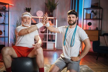 Spor eğitmeni idmandan sonra yaşlı adama beşlik çakıyor.