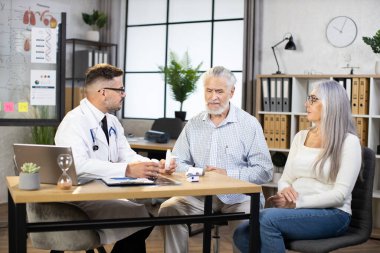 Doktor normal randevu sırasında olgun bir çiftle konuşuyor.